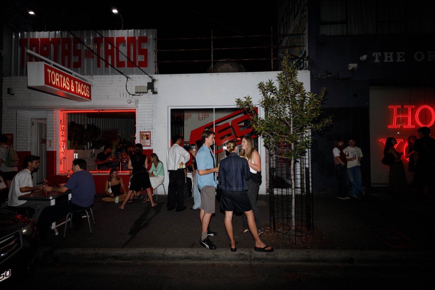 Rusty pop-up brand activation — customers gathered outside the event at night